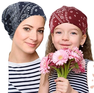 Modische Mutter und Tochter mit Baumwoll-Beanies im Paisleymuster und rosa Blumen