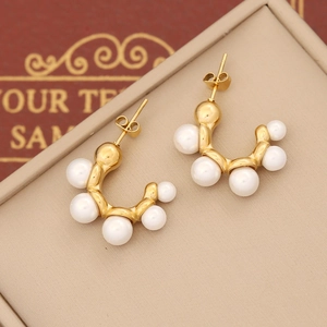 Elegant C-shaped gold-plated earrings featuring rows of cream pearls on a leather background