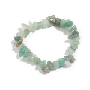 Macro shot of irregular light green natural agate stones on an elastic crystal bracelet