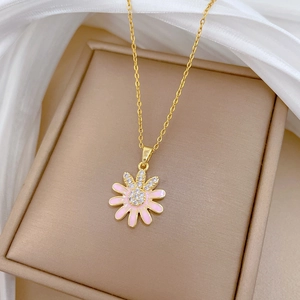 Detailed close-up of pink sunflower pendant with small crystals on a golden chain