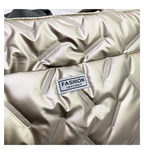 Macro detail of champagne gold quilted nylon bag with Fashion Instinct label tag