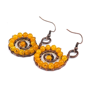 Macro view of handmade spiral copper wire wrapped around amber yellow agate stone bead