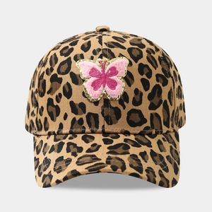 Close-up of leopard print baseball cap featuring a pink plush butterfly sequin patch