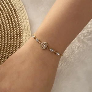Bracelet élégant en chaîne dorée avec cinq pierres ovales sur le poignet d'un modèle