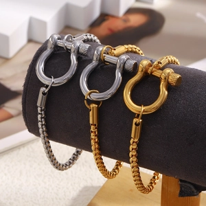 Détail macro de bracelets à boucle fer à cheval dorés et argentés sur support