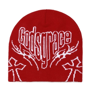 Detail of red knit beanie with white godsgrace gothic text and cross embroidery patterns