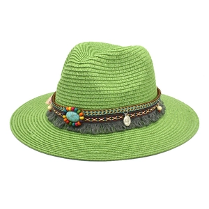 Detail of green straw fedora featuring bohemian beads, turquoise accents and tassels