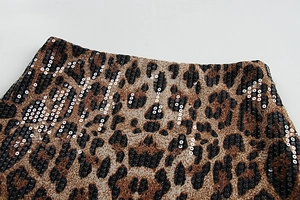 Dettaglio del tessuto leopardato con paillettes argentate lucide e cuciture fini