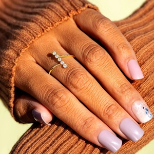 Detailed close-up of an adjustable gold silver ring with five round cubic zirconia stones