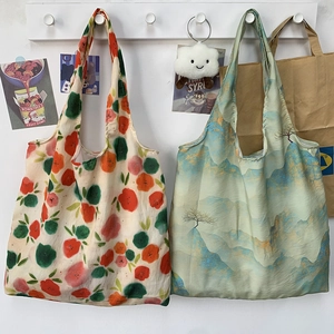 Detail view of floral and Chinese landscape print canvas tote bags hanging on white hooks