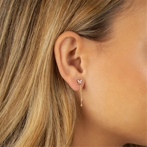 Detail of gold butterfly tassel earrings with sparkling cubic zirconia on a model