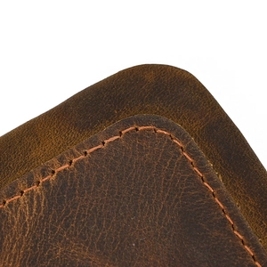 Macro shot of dark brown genuine leather showing fine stitching and natural texture details
