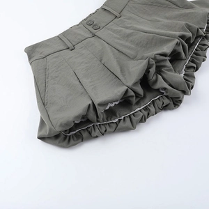Detailansicht der gefalteten Ballon-Shorts in Khaki mit Spitzenbesatz und Doppelknöpfen