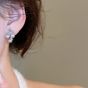 Detail of elegant silver stud earring with lavender pearls and diamonds on model