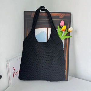 Close-up of black hollow knit tote bag with heart pattern and tulip flower decor