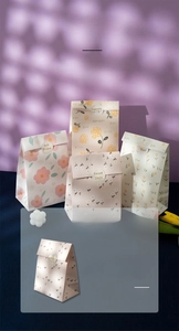 Close-up of floral gift bags with 'Sweet Days' stickers and artistic plant shadows