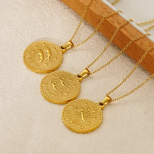 Detail of vintage gold zodiac necklaces featuring Pisces Gemini and Scorpio relief pendants