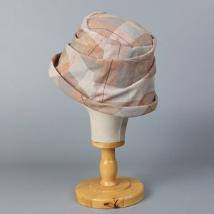 Detail of blue plaid pleated cloche hat texture on a vintage wooden head stand