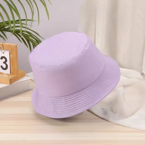 Reversible light purple canvas bucket hat on a wooden table with lifestyle decor