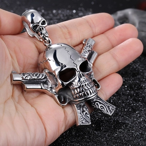 Gothic punk stainless steel skull pendant with crossed dual pistols shown in hand