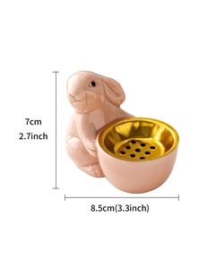 Detailed view of a pink ceramic rabbit figurine incense burner with gold interior