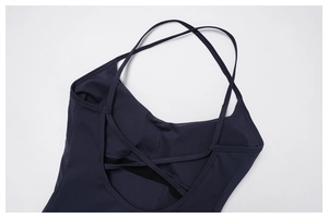 Dettaglio di un top da yoga blu scuro con schiena incrociata e spalline elastiche