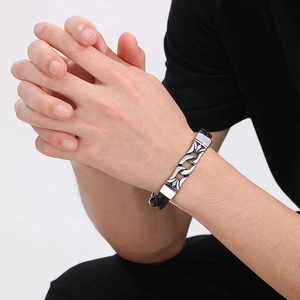 Detail of men's punk woven leather bracelet with silver steel chain links on wrist