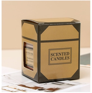 Detail of square glass scented candle in a brown kraft window box with plant extracts