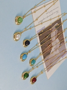 Various vintage gold pearl necklaces with teardrop gemstones in seven vibrant colors