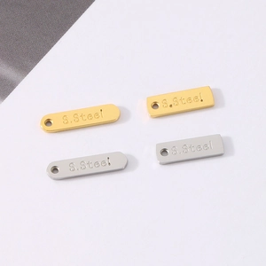 Detailed macro view of gold and silver rectangular stainless steel tags with S.Steel engraving