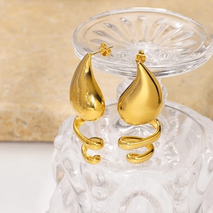 18k gold plated stainless steel teardrop spiral earrings on a decorative glass stand