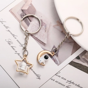 Creative astronaut keychains with gold moon and star charms on an open book background