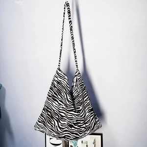 Vertical view of large canvas tote bag featuring zebra print and long shoulder straps