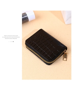 Macro detail of black crocodile pattern leather wallet with premium golden zipper hardware
