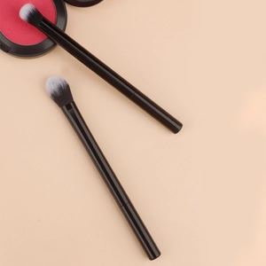 Detail of two professional makeup brushes with matte black handles and gradient bristles