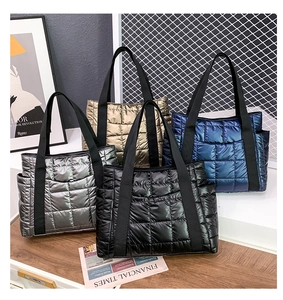 Detailed display of four quilted puffer tote bags in metallic silver, gold, and navy blue