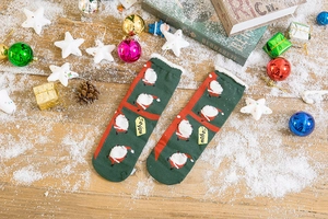 Close-up of green Christmas socks with Santa Claus pattern and white fuzzy cuffs