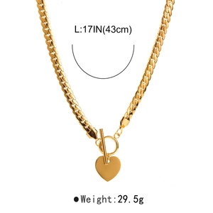Detail of 17 inch gold heart pendant necklace with toggle clasp and thick Cuban link
