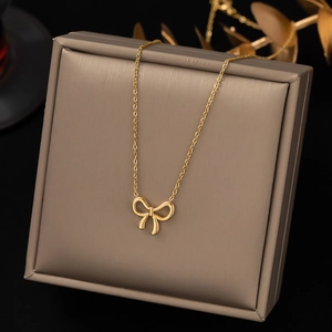 Elegant gold bow pendant necklace for women displayed on a luxury jewelry gift box