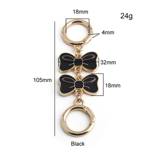 Detail of 105mm black enamel bow chain extender with golden spring ring clasps