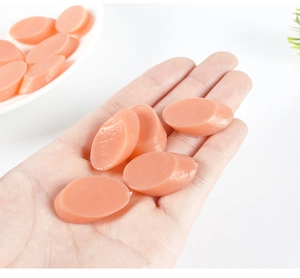 Macro detail of pinkish orange sealing wax beads held in hand for creative DIY crafts