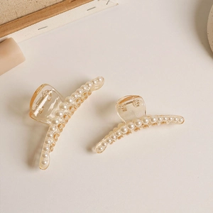 Detail of two champagne pearl hair claws showing transparent resin and glossy finish