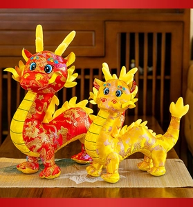 Dettaglio dei peluche a forma di drago dello zodiaco cinese in raso rosso e oro