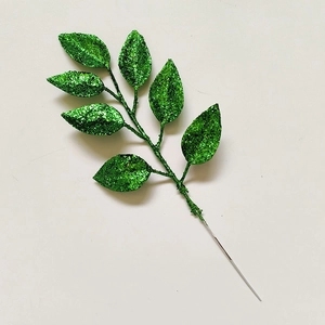 Detailed macro shot of a green glitter artificial leaf for DIY Christmas wreath decor