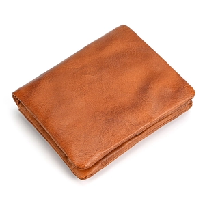 Detail view of the side fold and natural texture of the brown leather wallet
