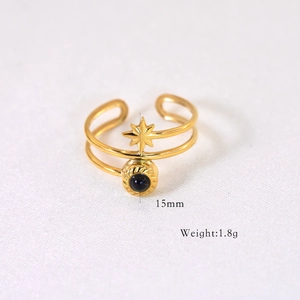 Détail d'une bague double dorée de 15mm avec étoile à huit branches et pierre sombre