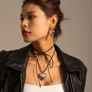 Detail of 3D heart-shaped necklace and mixed-metal earrings with a polished finish