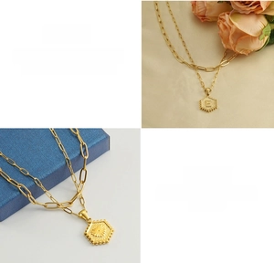 Close-up of double-layer gold titanium steel necklace with hexagonal letter E pendant