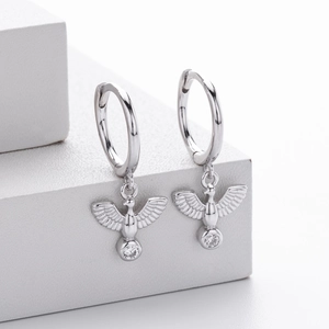 Detailed close-up of bird-shaped silver earrings with sparkling white cubic zirconia stones