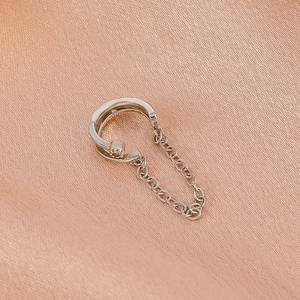 Silberne C-förmige Earcuff-Kette mit Zirkonia auf weichem Seidenhintergrund